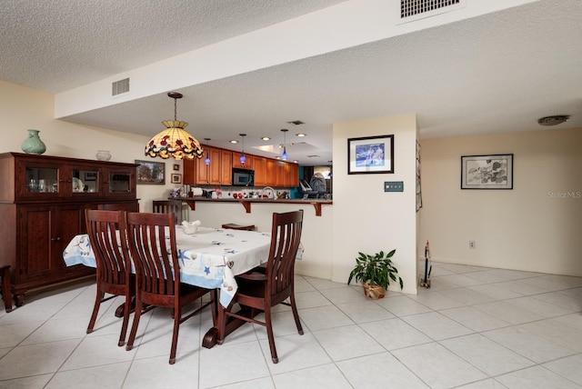 tiled dining area featuring a textured ceiling