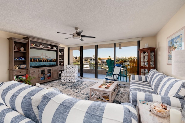 living room with floor to ceiling windows, ceiling fan, and a textured ceiling