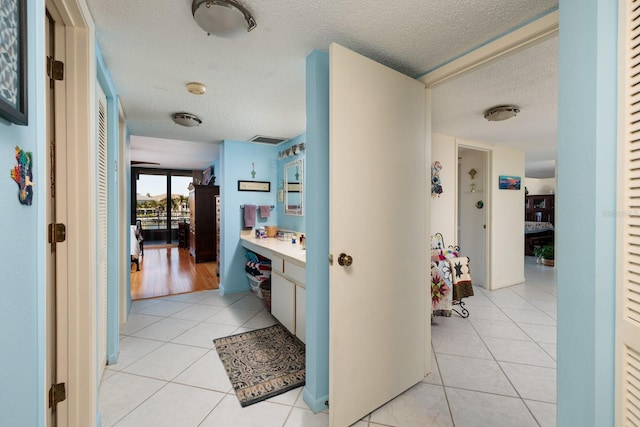 bathroom with vanity, tile patterned flooring, and a textured ceiling