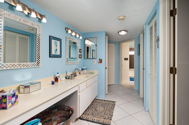 bathroom featuring vanity, tile patterned flooring, and a textured ceiling