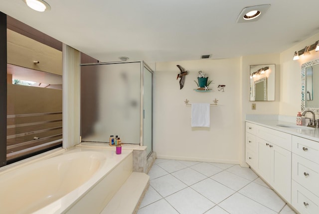 bathroom featuring tile patterned flooring, shower with separate bathtub, and vanity