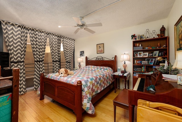 bedroom with a textured ceiling, ceiling fan, and light hardwood / wood-style flooring