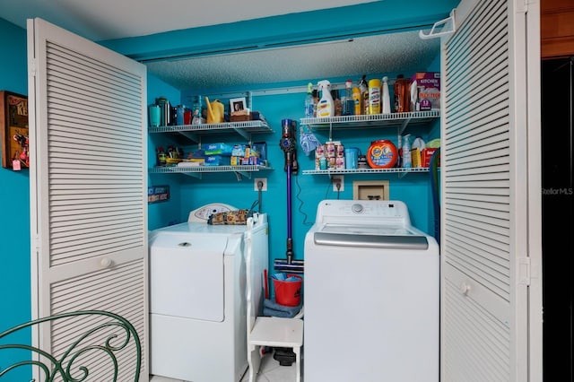 laundry area with washer and clothes dryer and a textured ceiling