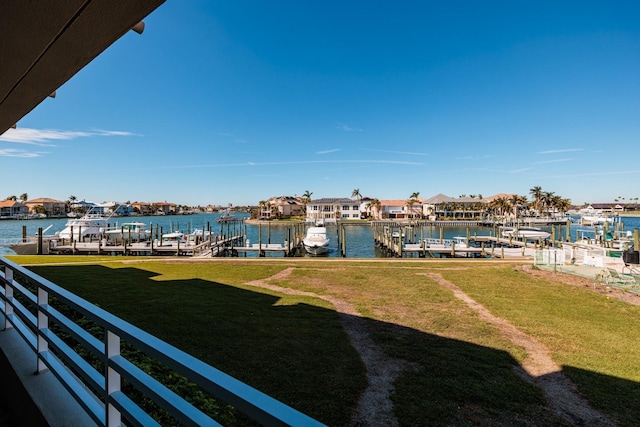 view of dock featuring a lawn and a water view