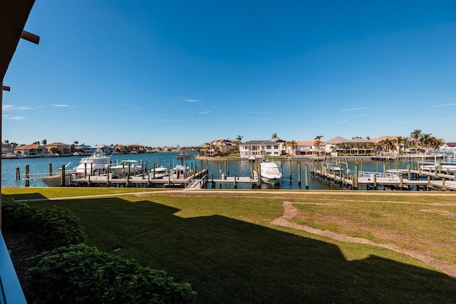 dock area with a lawn and a water view