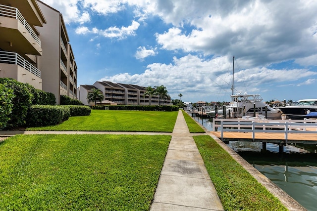 view of dock with a water view and a lawn