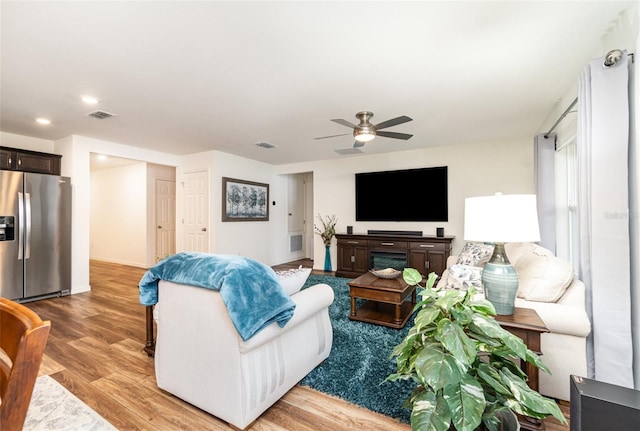 living room featuring ceiling fan and hardwood / wood-style floors