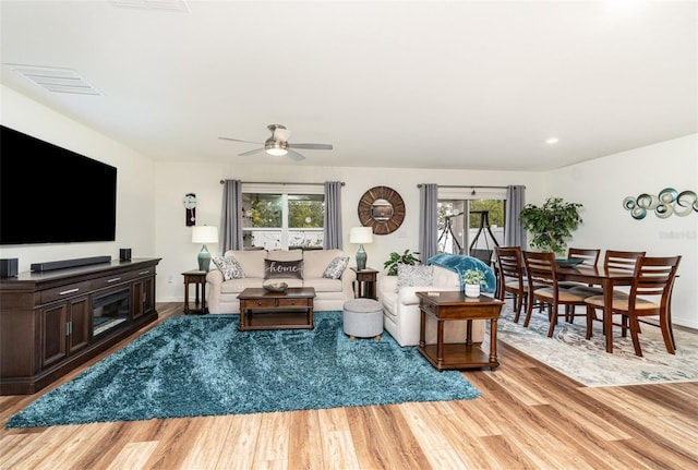 living room with light hardwood / wood-style floors and ceiling fan