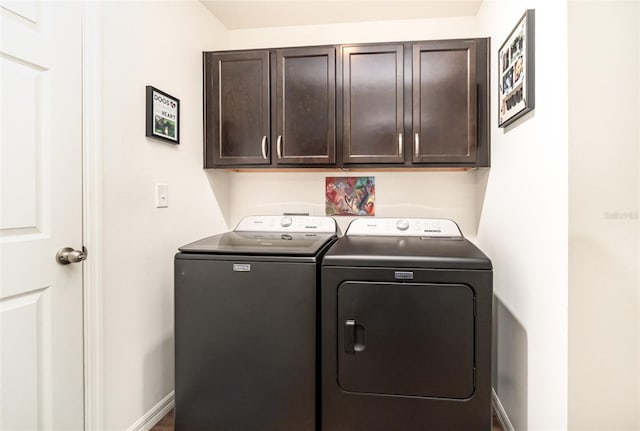 washroom with cabinets and washer and clothes dryer