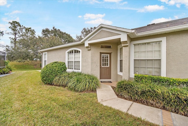 doorway to property featuring a lawn