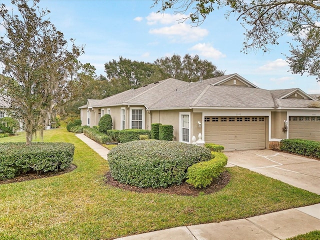 single story home featuring a garage and a front lawn