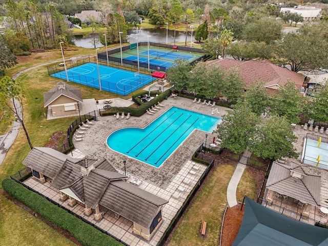 view of swimming pool featuring basketball court, tennis court, and a water view