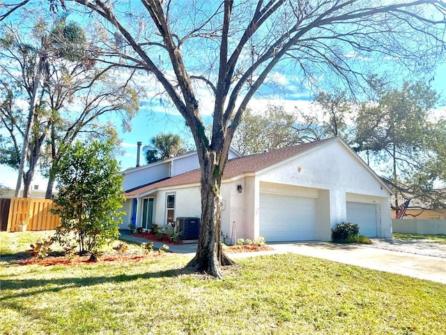 view of front of house featuring central AC, a garage, and a front yard