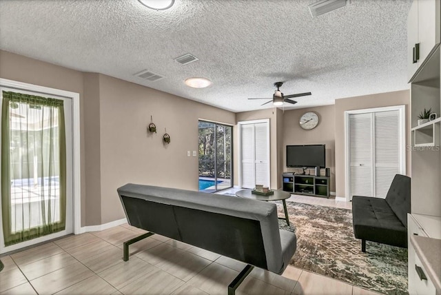 rec room with ceiling fan and a textured ceiling