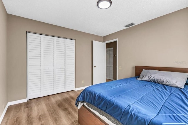 bedroom with hardwood / wood-style floors and a textured ceiling