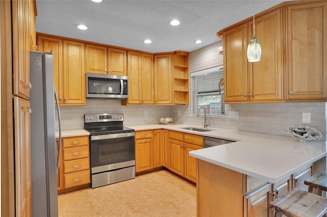 kitchen featuring sink, a kitchen breakfast bar, kitchen peninsula, pendant lighting, and stainless steel appliances