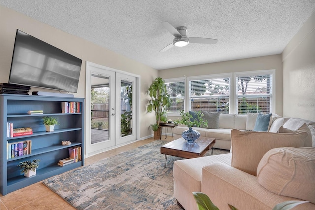 living room featuring tile patterned flooring, ceiling fan, french doors, and a textured ceiling