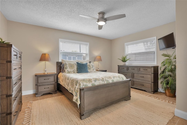 bedroom with light tile patterned floors, a textured ceiling, and ceiling fan