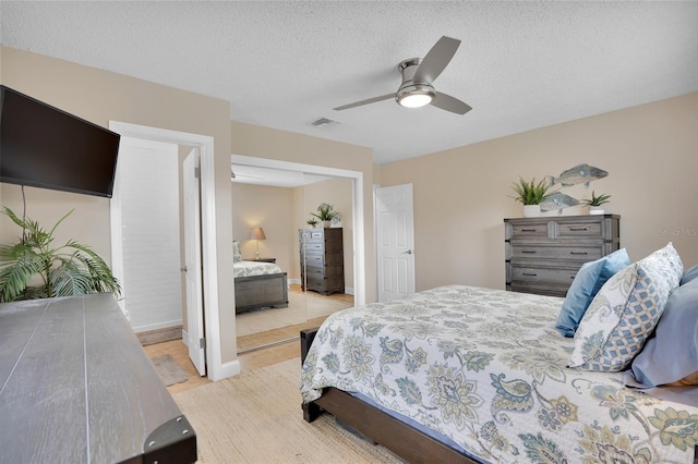 tiled bedroom featuring ceiling fan and a textured ceiling