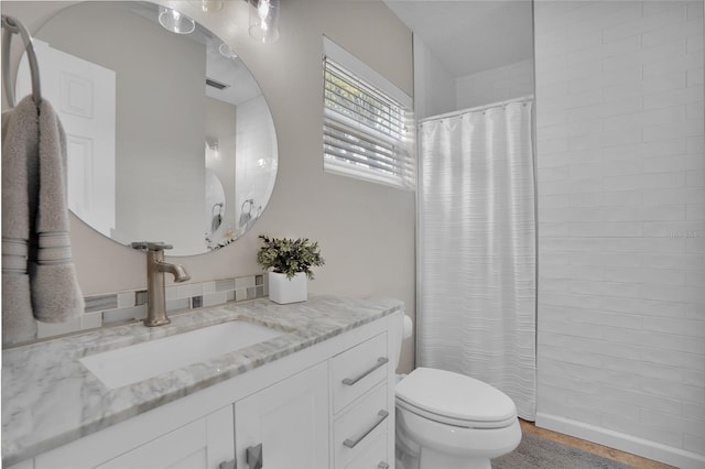 bathroom featuring vanity, toilet, and curtained shower