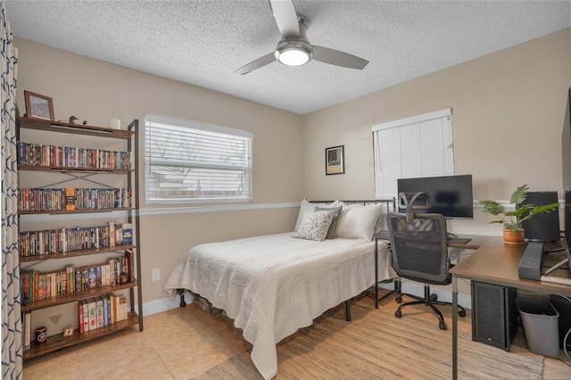 tiled bedroom featuring a textured ceiling and ceiling fan