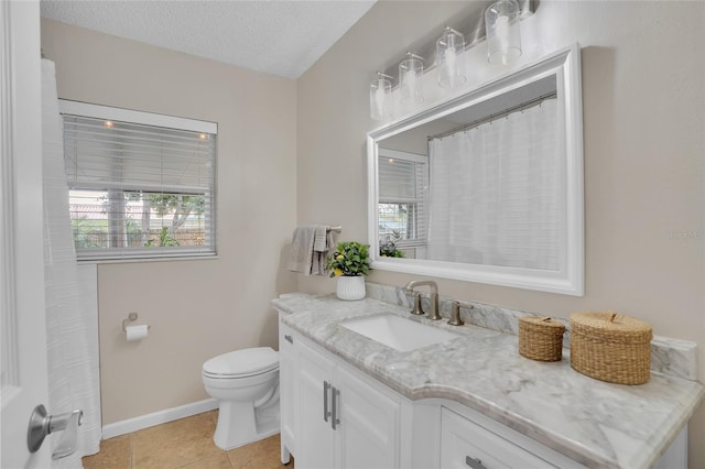 bathroom with vanity, a healthy amount of sunlight, a textured ceiling, and toilet