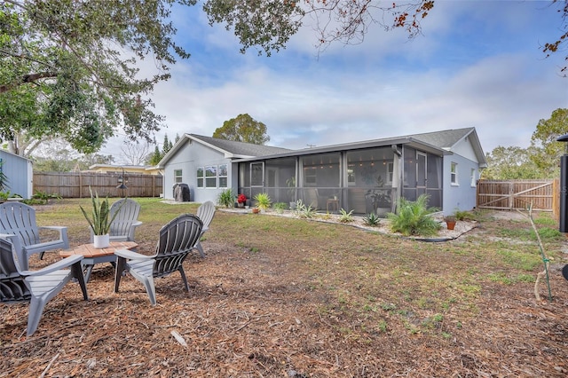 rear view of property featuring a lawn and a sunroom