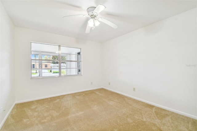 empty room with ceiling fan and light carpet