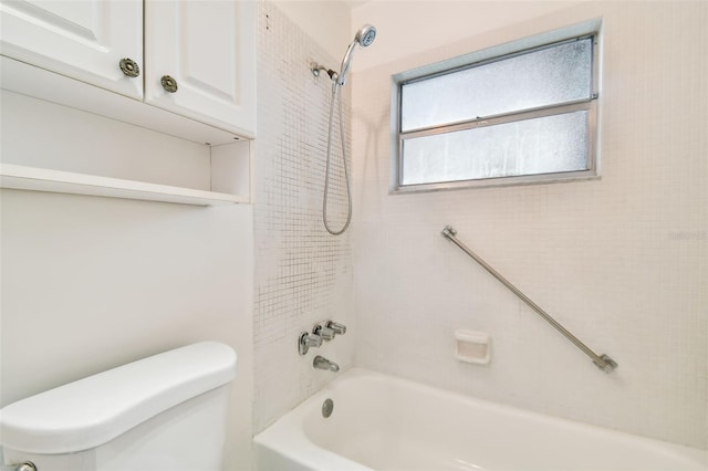 bathroom featuring tiled shower / bath combo and toilet