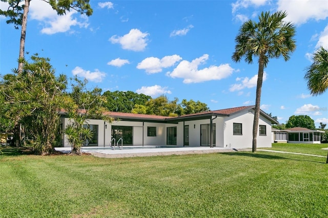 rear view of property featuring a yard and a patio