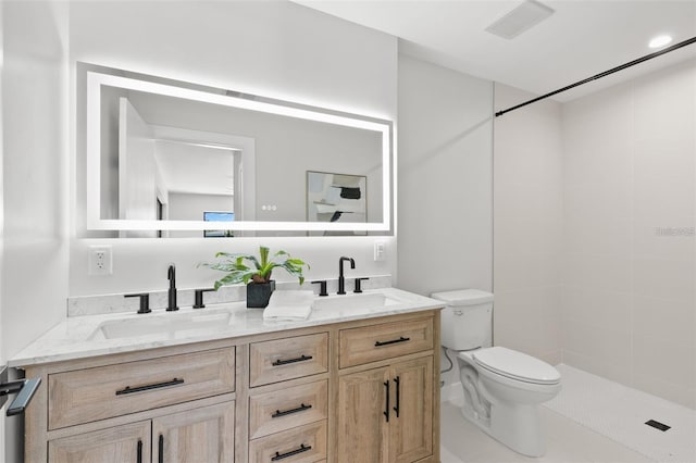 bathroom featuring tiled shower, toilet, and vanity