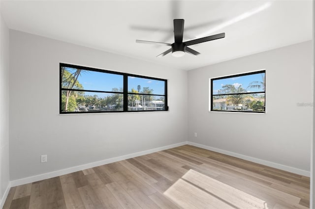 spare room with ceiling fan, a healthy amount of sunlight, and light hardwood / wood-style floors