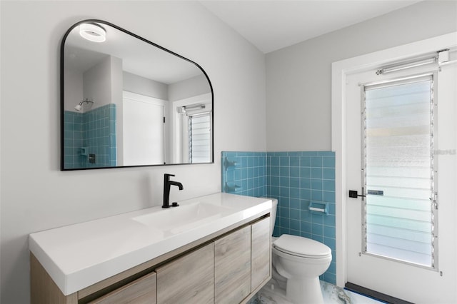 bathroom with tile walls, toilet, and vanity