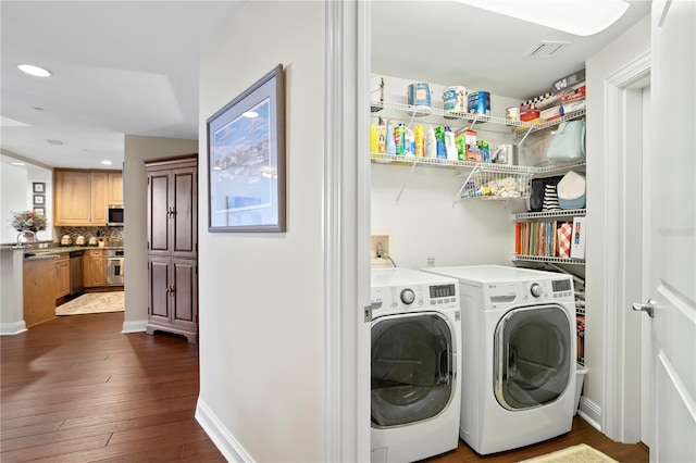 laundry room with independent washer and dryer and dark hardwood / wood-style floors