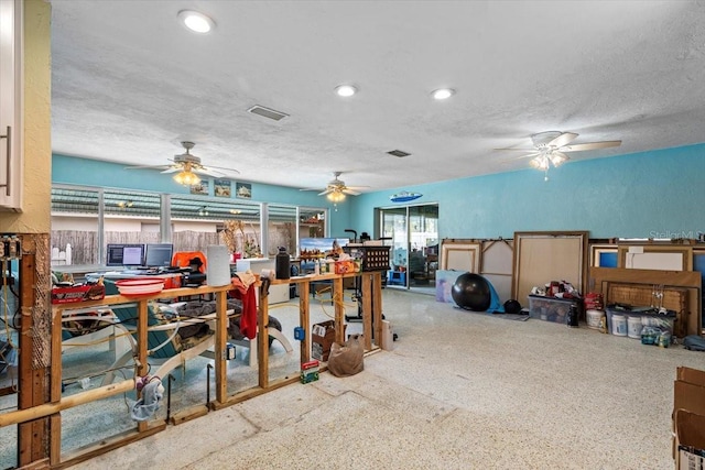 miscellaneous room with ceiling fan and a textured ceiling