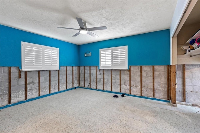 interior space with ceiling fan and a textured ceiling