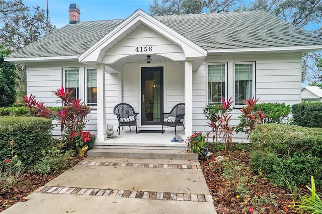 view of exterior entry featuring covered porch