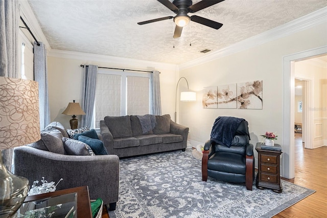 living room with hardwood / wood-style floors, ornamental molding, a textured ceiling, and ceiling fan