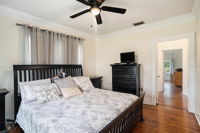 bedroom with ornamental molding, dark hardwood / wood-style floors, and ceiling fan