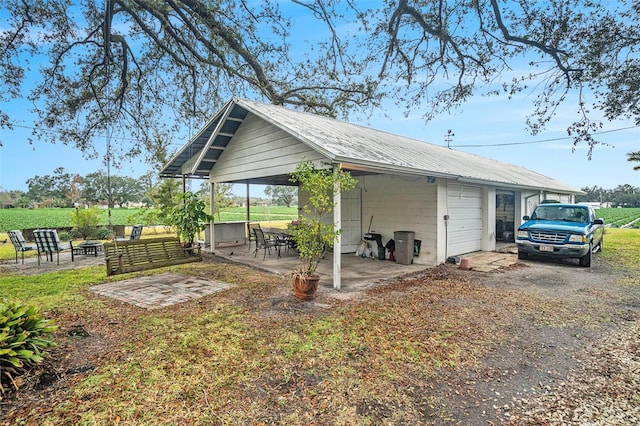 exterior space with a garage, metal roof, and driveway