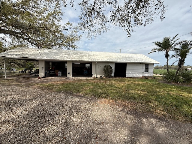 back of property with a yard, driveway, and an attached carport