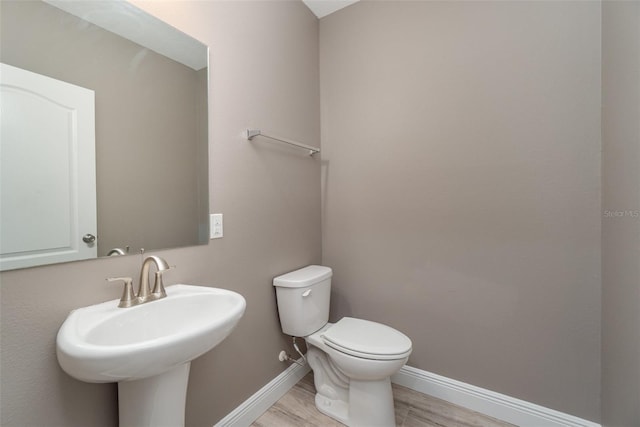 bathroom with sink, wood-type flooring, and toilet