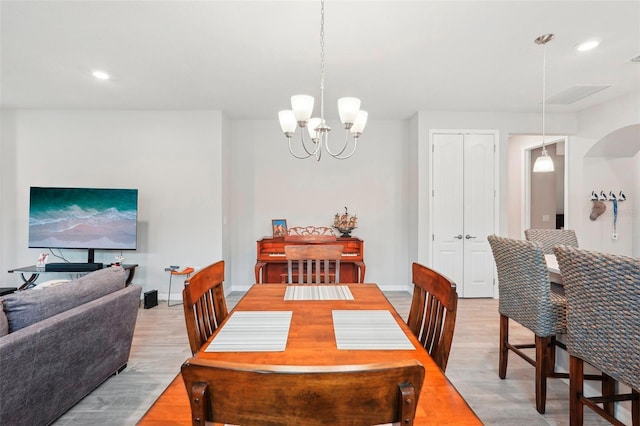 dining space featuring hardwood / wood-style flooring and a chandelier