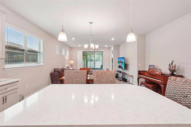 kitchen featuring a notable chandelier, light stone counters, and decorative light fixtures