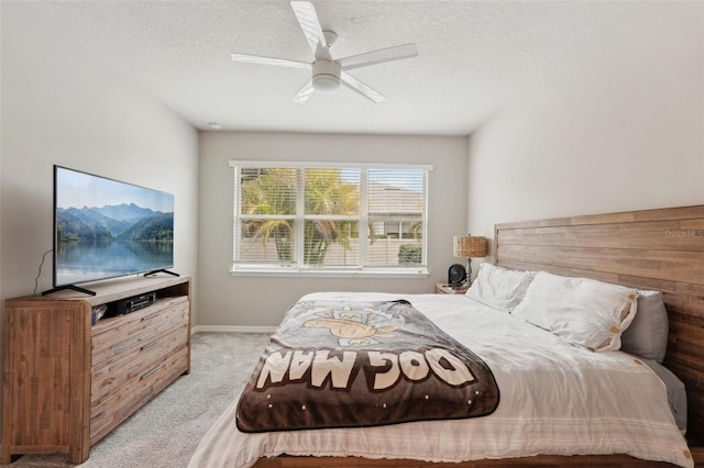 carpeted bedroom with ceiling fan and a textured ceiling