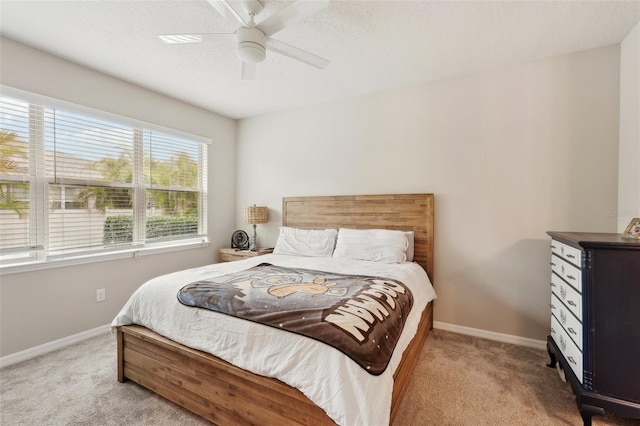 bedroom with light colored carpet, a textured ceiling, and ceiling fan