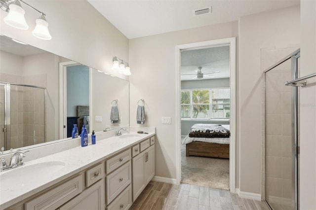 bathroom with vanity, ceiling fan, and a shower with shower door