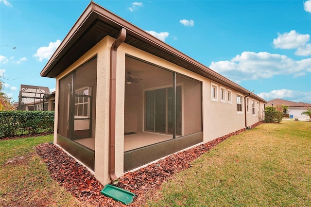 view of side of home with a sunroom and a yard