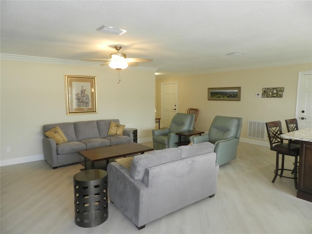 living room featuring ceiling fan, ornamental molding, and light hardwood / wood-style floors