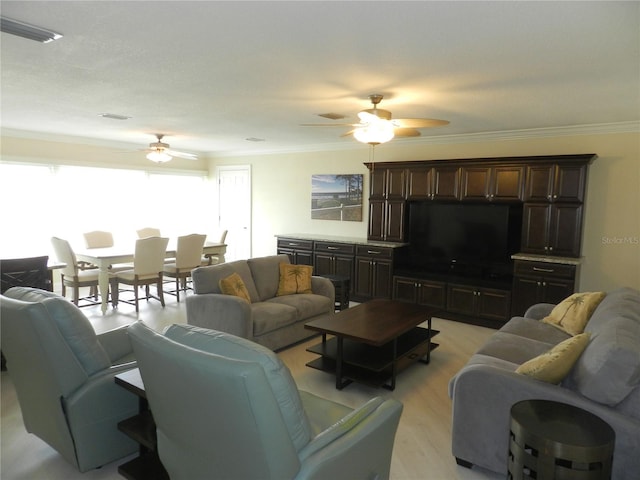 living room featuring light hardwood / wood-style flooring, ornamental molding, and ceiling fan